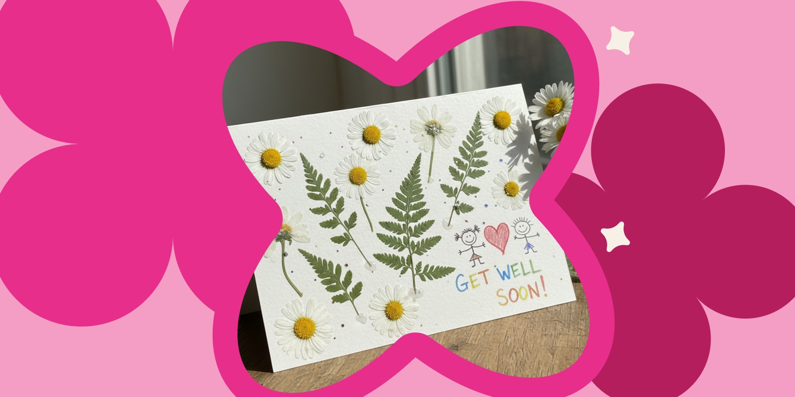 Handgemachte Grusskarte mit gepressten Gänseblümchen und Farnblättern auf weissem Papier